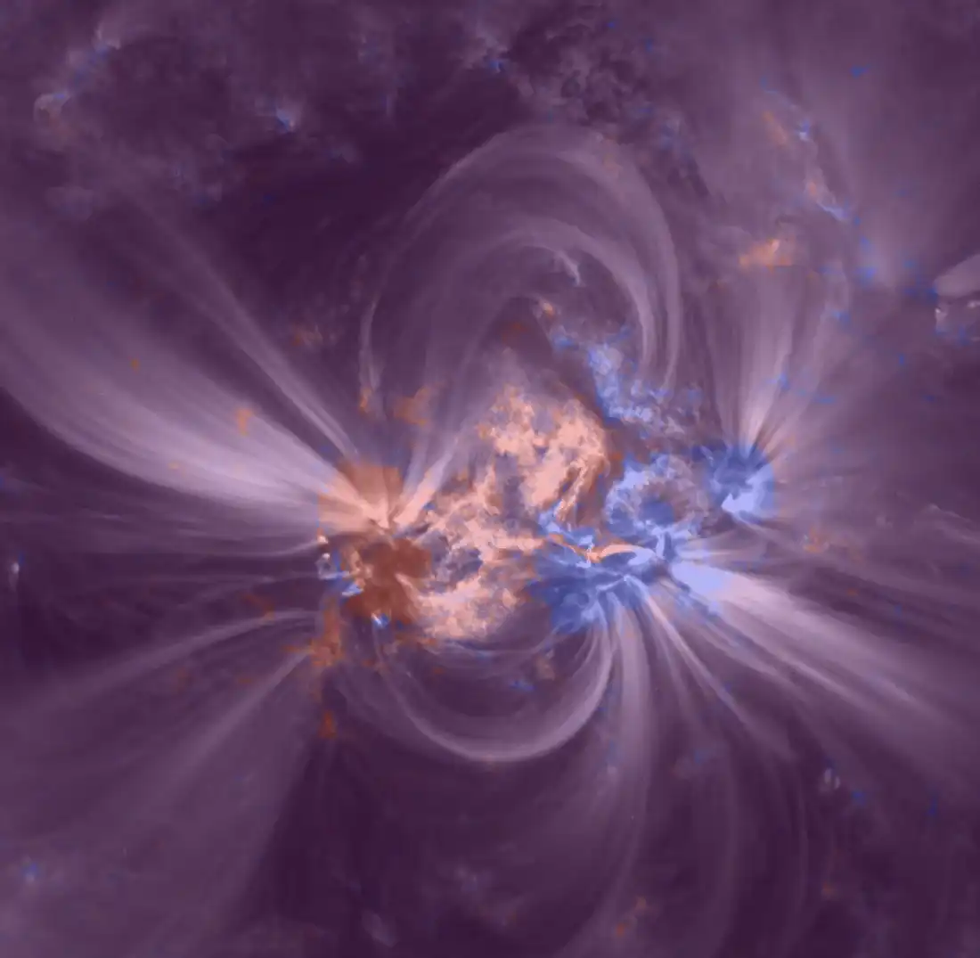 Solar active region with the surface magnetic field in red and blue under the bright loops of the corona